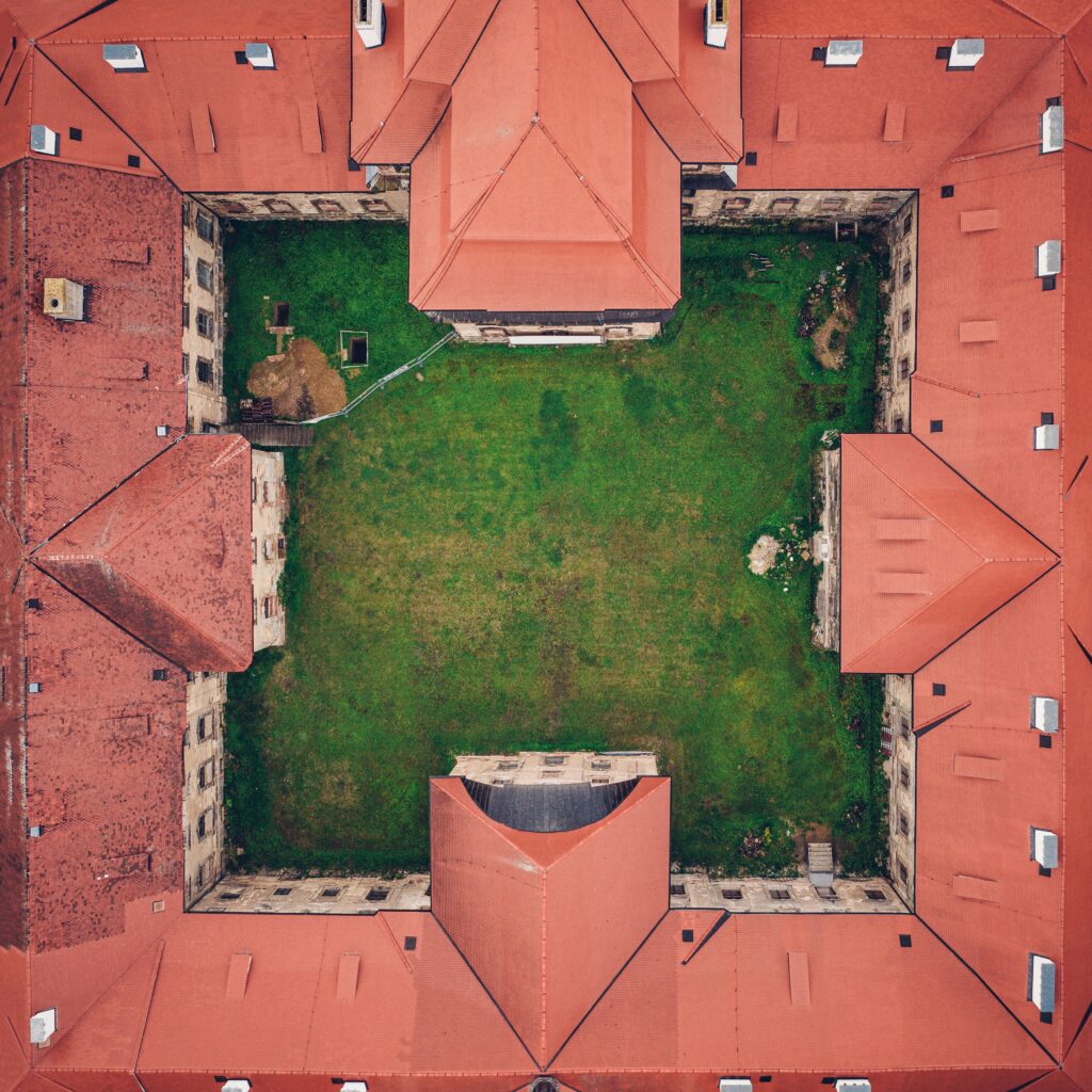 Aerial view of a courtyard enclosed by red-roofed buildings, symbolizing healthy boundaries that create protected, balanced space for emotional well-being and connection.